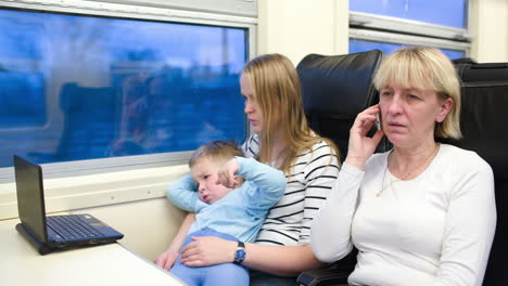 Passengers-in-the-train-watching-video-on-laptop-and-talking-phone