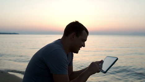 Hombre-Usando-Tableta-En-La-Playa