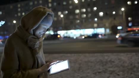Woman-typing-message-on-pad-while-walking-in-the-evening