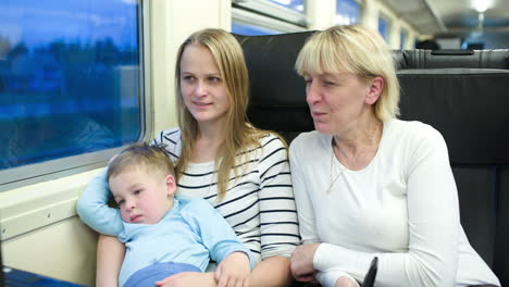 Mother-son-and-grandmother-traveling-by-train