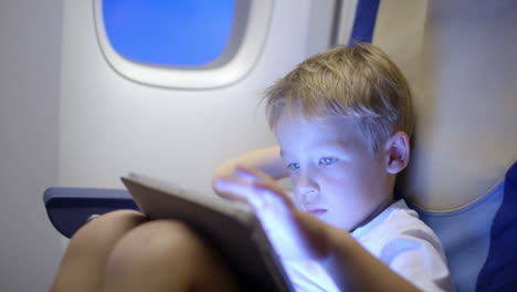 Gelangweilter-Oder-Müder-Junge-Im-Flugzeug-Mit-Tablet-Computer