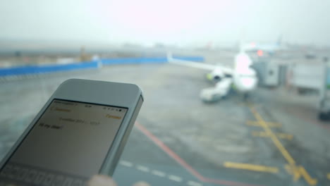 Textnachricht-Auf-Dem-Smartphone-Am-Flughafen-Eingeben