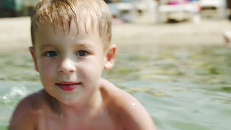 Little-boy-swimming-on-board-near-the-shore