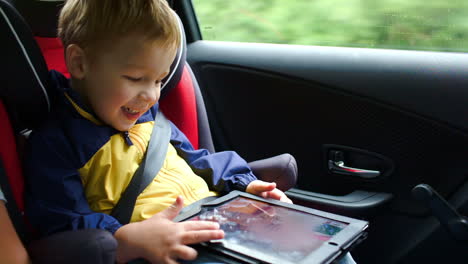 Kleiner-Junge,-Der-Im-Auto-Auf-Einem-Tablet-Computer-Spielt