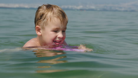 Little-boy-trying-to-swim-on-board-in-the-sea