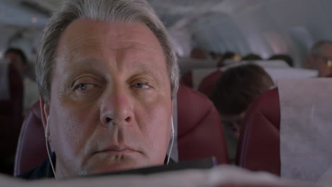 Sleepy-man-listening-to-music-in-airplane