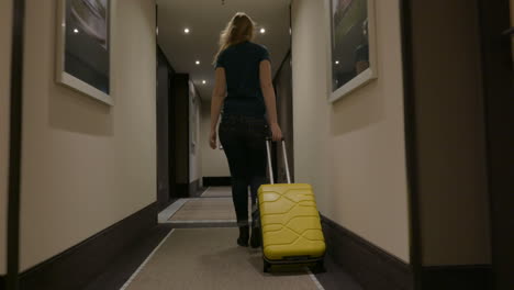 Woman-Walking-along-the-Hotel-Passage-with-Trolley-Bag