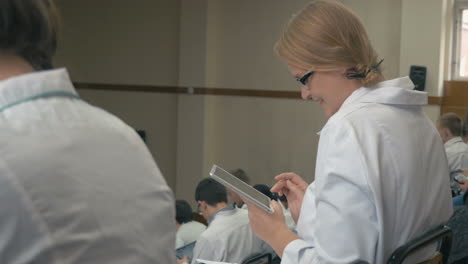 Smiling-medical-student-with-pad-on-the-lecture