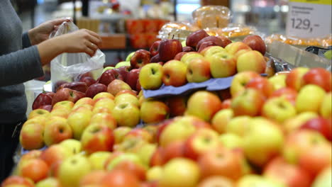 Frau-Im-Supermarkt-Legt-Äpfel-In-Eine-Plastiktüte