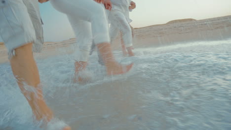 Four-people-splashing-sea-water-with-feet