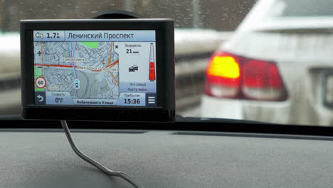 Zeitraffer-Eines-Autos-Mit-Angehaltenem-GPS-Im-Vordergrund