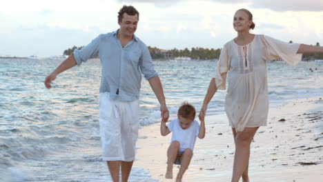 Parents-and-their-child-walking-along-the-beach