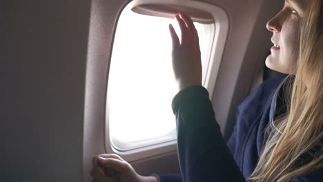 Mujer-Cerrando-Las-Persianas-En-El-Avión-Y-Usando-Tablet-Pc