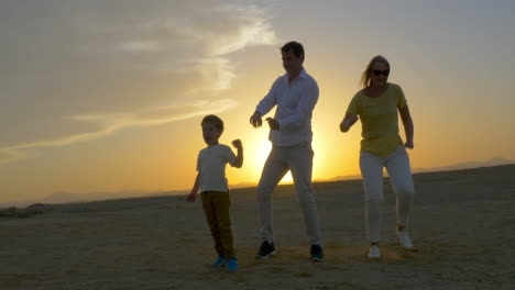 Eltern-Und-Sohn-Tanzen-Bei-Sonnenuntergang