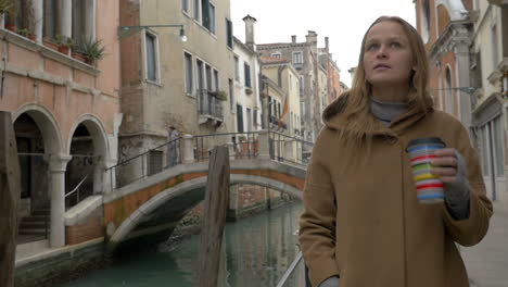 Woman-having-coffee-while-walking-in-Venice