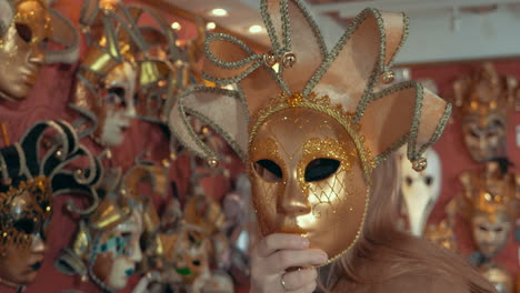 Woman-in-the-store-trying-on-golden-Venetian-mask