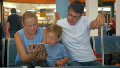 Familie-Wartet-Mit-Tablet-PC-Auf-Die-Abreise
