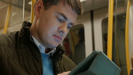 Man-Using-Tablet-PC-in-Metro-Train