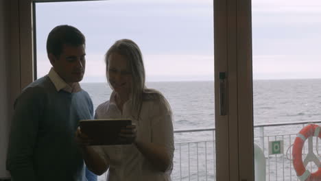 Young-couple-using-tablet-PC-on-board-the-ship