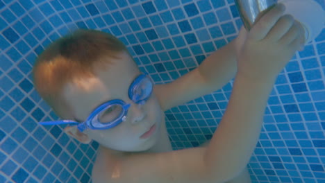 Boy-in-Goggles-Holding-Breath-in-Swimming-Pool