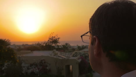 Man-putting-on-spectacles-to-enjoy-the-sunset