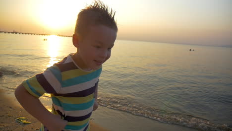 Child-making-angry-face-on-the-beach-at-sunset