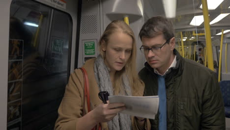 Erwachsenes-Paar-Mit-Einer-Karte-In-Der-U-Bahn