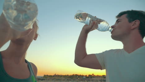 Two-People-Drinking-Water-from-Plastic-Bottles