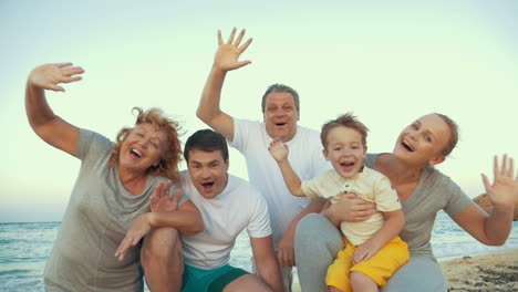 Big-happy-family-waving-hands-at-the-seaside