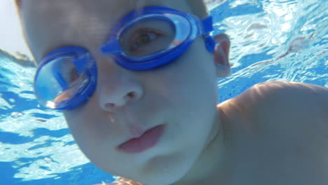 Underwater-swimming-of-a-child-in-goggles
