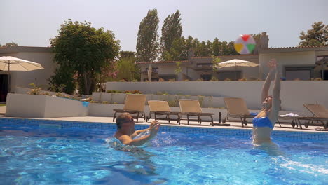 Man-and-woman-playing-with-ball-in-the-pool