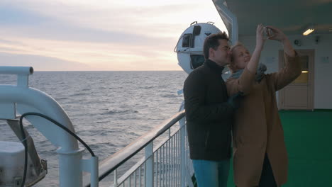 Young-couple-making-phone-selfie-on-shipboard
