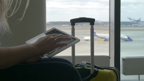 Woman-waiting-for-the-flight-with-tablet-PC