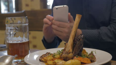 Man-with-phone-making-photo-of-a-served-dish