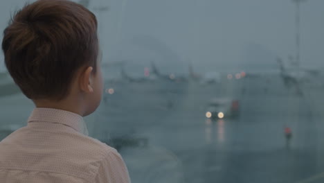 Child-is-attracted-with-airport-view-in-the-window