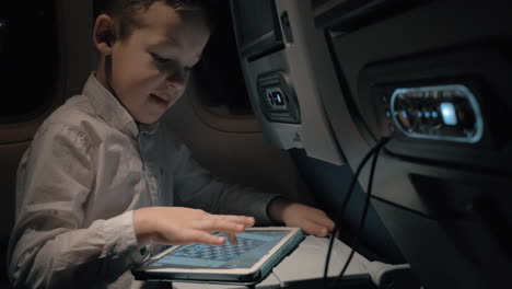 Boy-with-pad-in-plane-He-entertaining-with-chess-game
