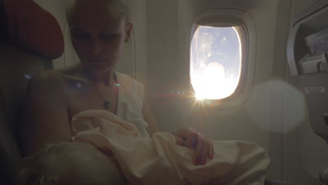 Woman-nursing-baby-during-the-flight-view-against-sun-flare