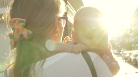 Mum-with-baby-walking-in-the-street-view-against-sun-flare