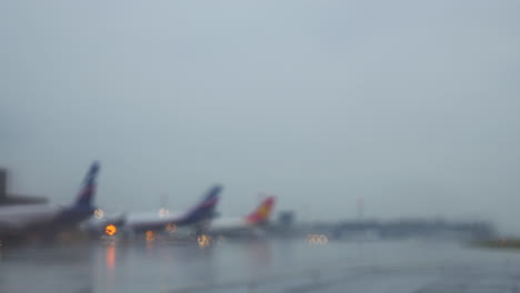 Airplanes-at-terminal-sitting-on-a-wet-taxiway