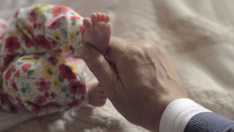 Grandad-touching-feet-of-baby-grandchild