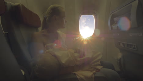Frau-Stillt-Ihre-Kleine-Tochter-Im-Flugzeugblick-Bei-Hellem-Sonnenlicht
