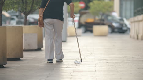 Elderly-woman-with-stick-walking-in-the-street