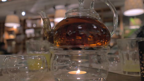 Glass-teapot-being-heated-with-candle