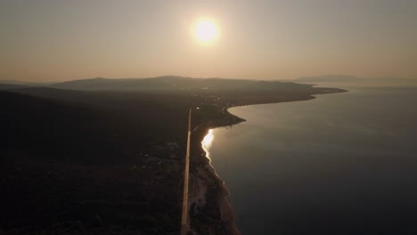 Aerial-scene-of-shoreline-sea-and-green-upland-at-sunset-Greece