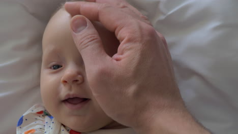 A-closeup-of-a-baby-girl-face-and-a-father-hand-touching-her