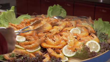A-large-dish-full-of-cooked-shrimps-with-lemon-and-lettuce-leaves