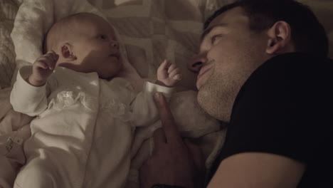 Dad-with-beloved-baby-daughter-lying-on-bed