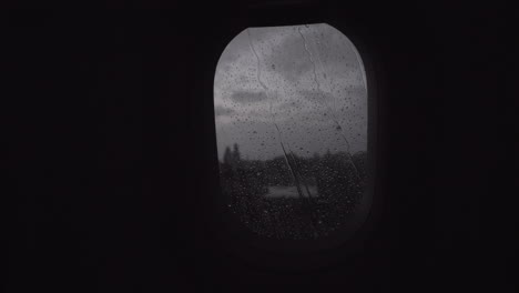 Flying-by-plane-in-rainy-evening-view-through-the-illuminator