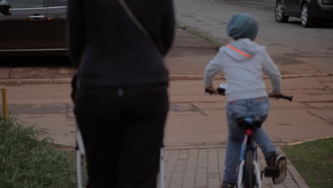 Mutter-Mit-Zwei-Kindern-Auf-Der-Straße,-älterer-Junge,-Der-Fahrrad-Fährt