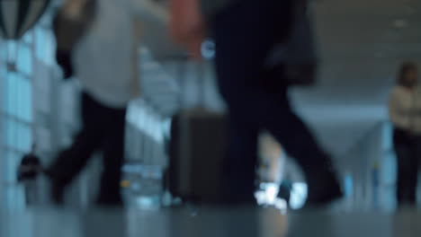 People-with-luggage-in-airport-hall-defocus